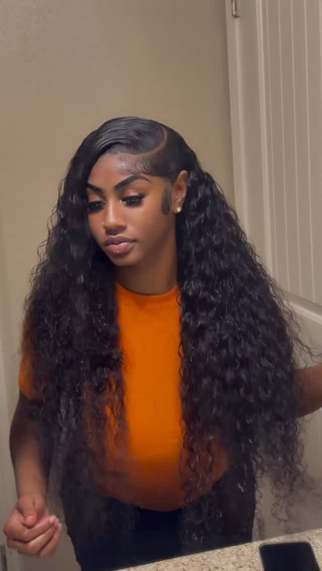 Woman with long dark curls styled with a deep side part
