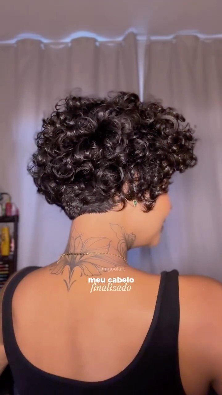 Short curly bixie with dense dark curls and tapered sides seen from behind