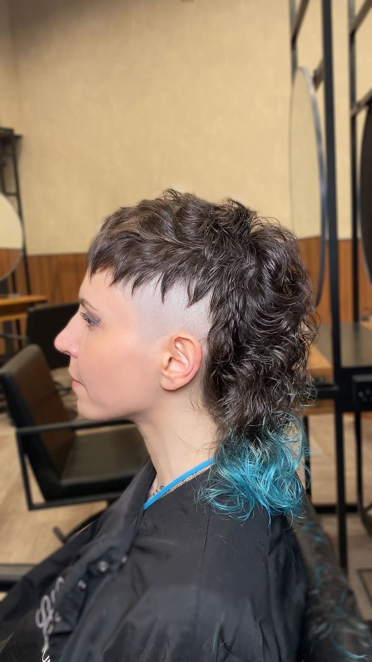 Tapered curly cut with short dark curls and turquoise-dyed ends