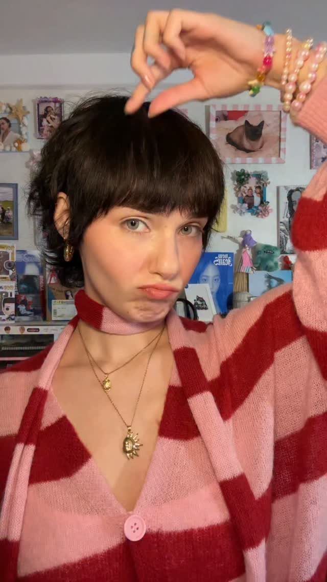Person with a short wavy dark pixie cut and piecey bangs