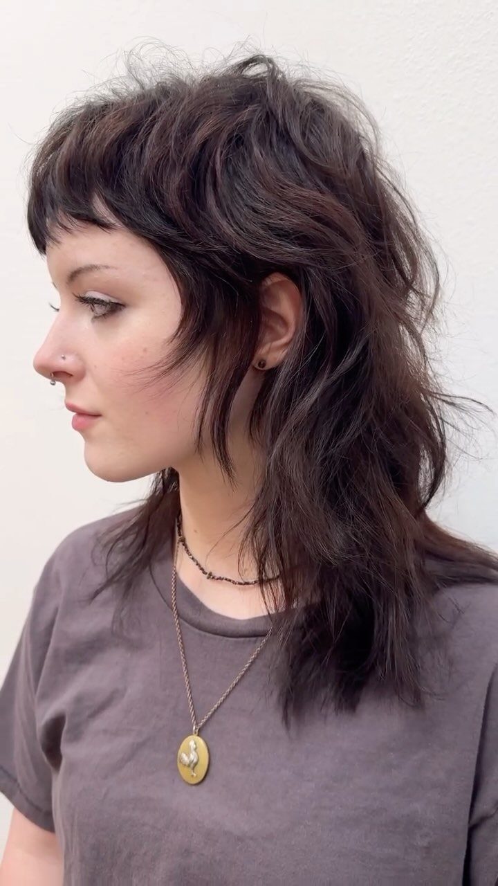 Shaggy dark wavy haircut with choppy layers and short fringe