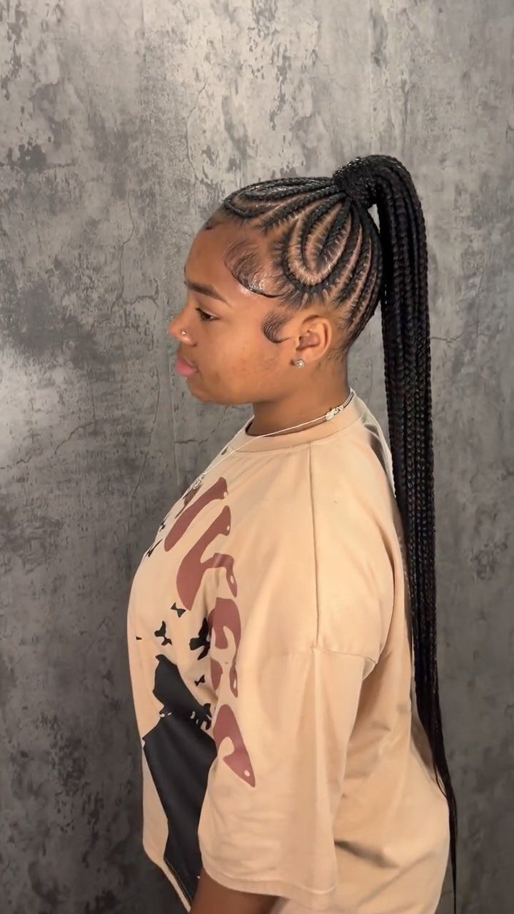Person with long black braided ponytail and curved cornrow sections
