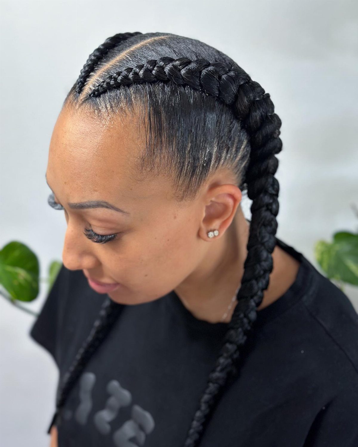 Woman wearing two thick black Dutch braids with a center part