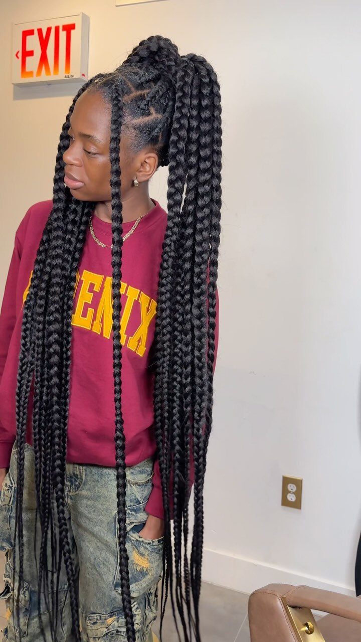 Woman with long, thick black braids gathered into a high ponytail