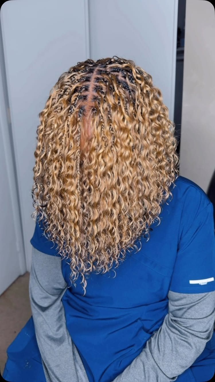 Layered blonde braids fall to varied lengths over a blue shirt