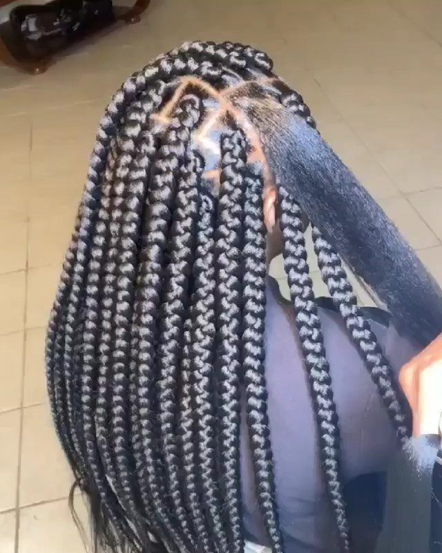 Mid-length black box braids with neat square parts gathered over one shoulder