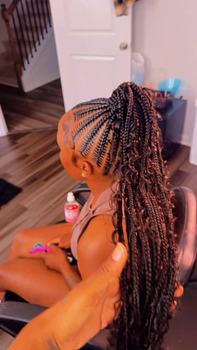 Woman wearing a high braided ponytail with long curly strands cascading down her back