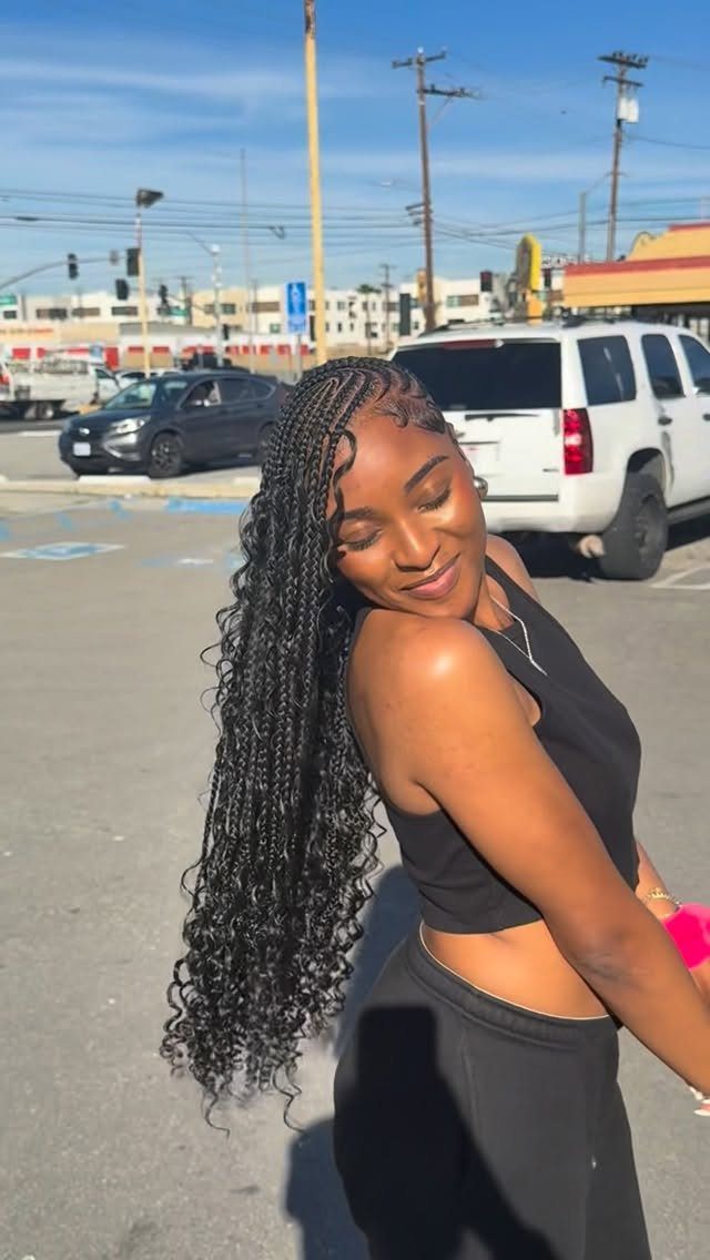 Woman showing long side-swept black braids with loose curly strands