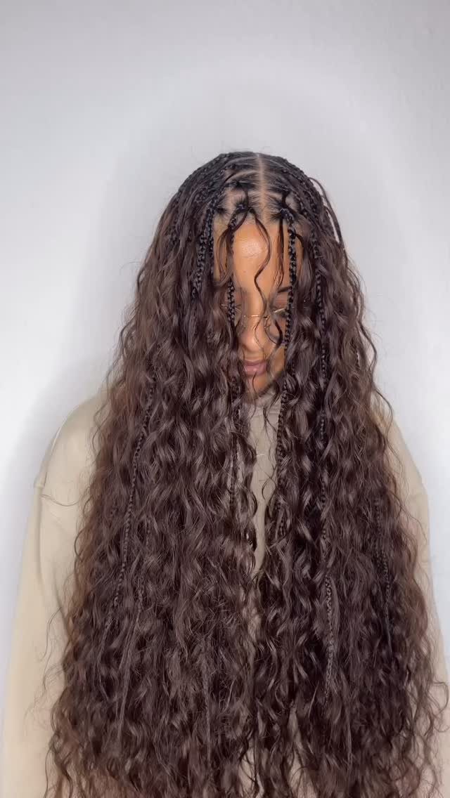 Long dark brown boho braids with loose curls and a center part