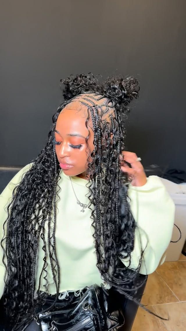 Person wearing long curly Fulani-inspired boho braids with patterned front cornrows and buns