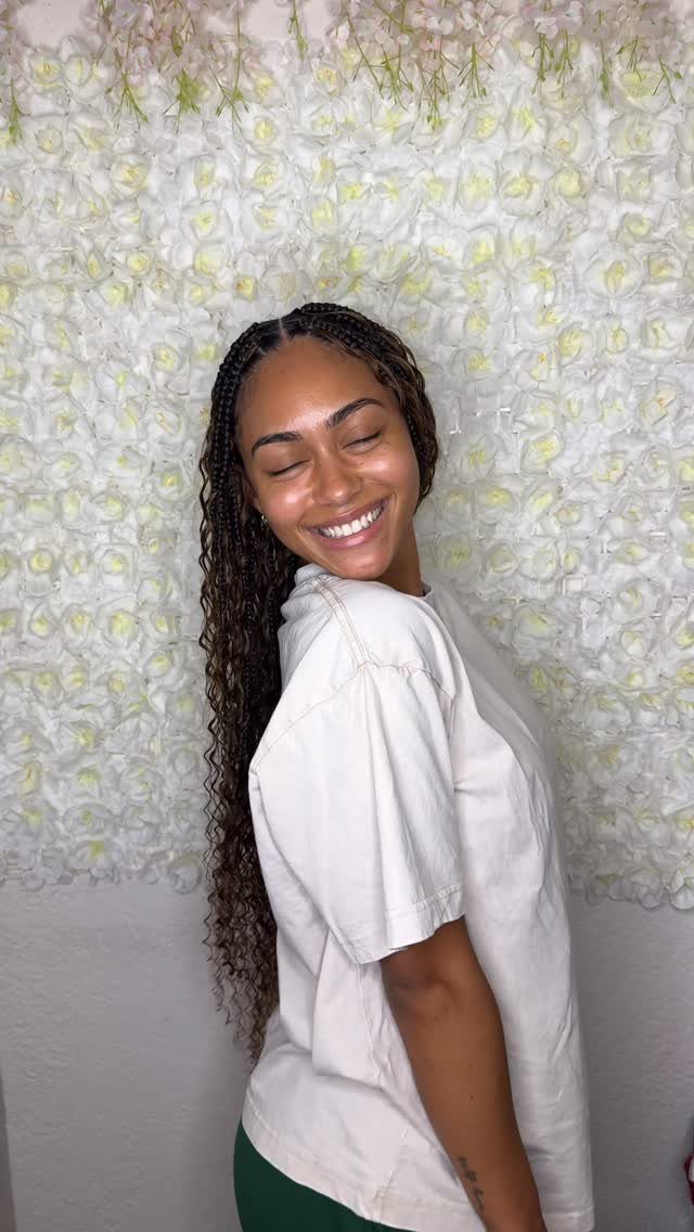 Woman showing long dark goddess box braids with loose wavy ends
