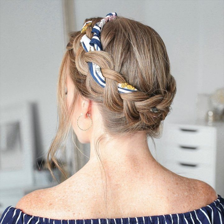 Woman showing braided low bun woven with a blue patterned scarf