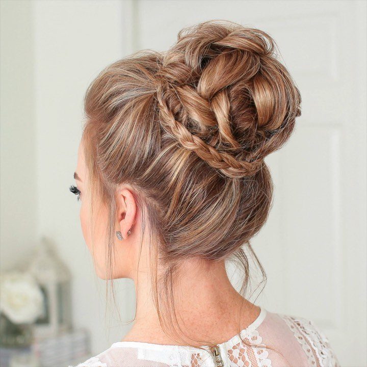 Woman wearing highlighted high bun wrapped with a braid around its base