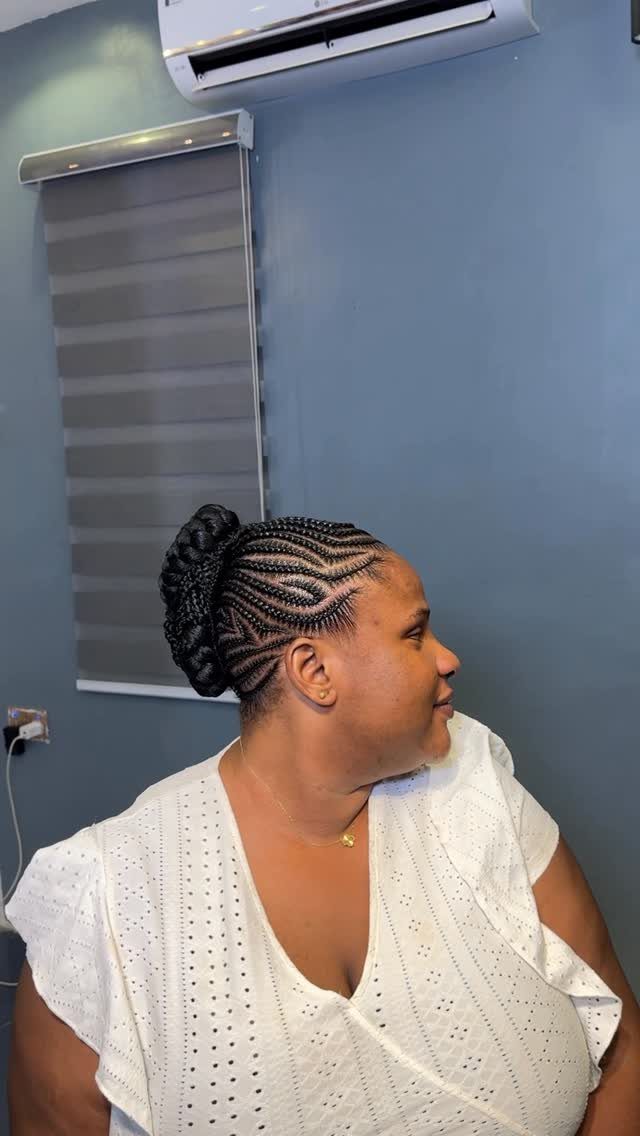 Cornrow braids gathered into a bun at the back of a woman's head