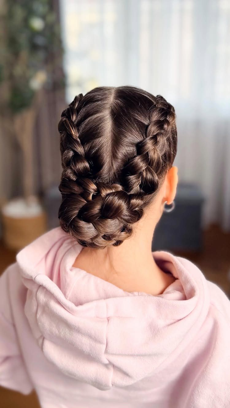 Dutch braids coil together into a low bun on the back of the head