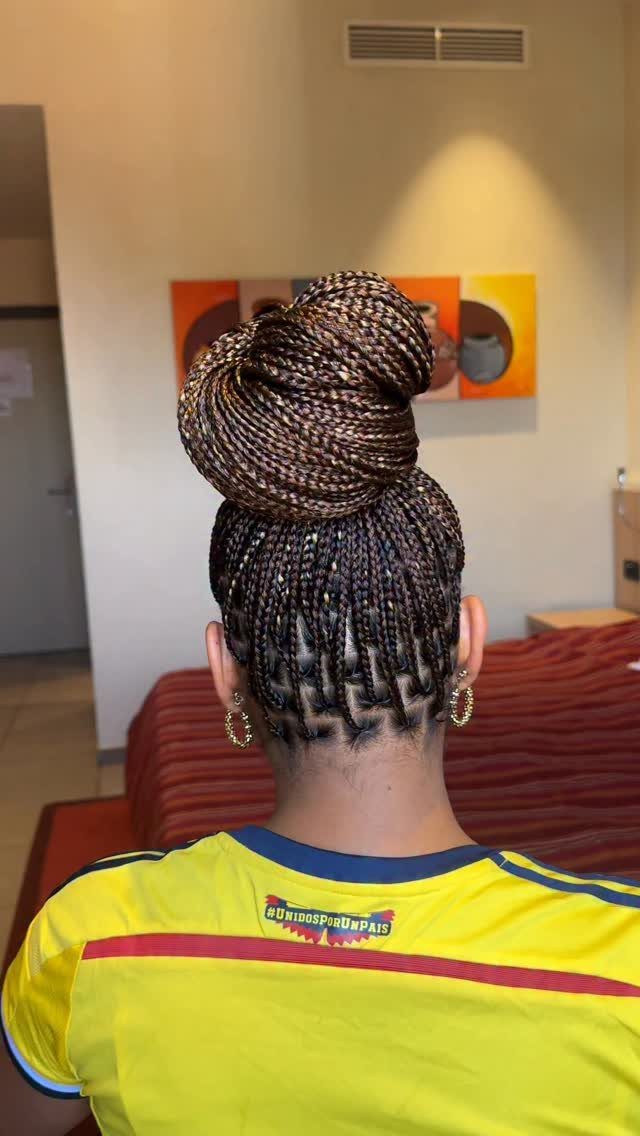 Braided bun hairstyle with microbraids gathered high above the nape