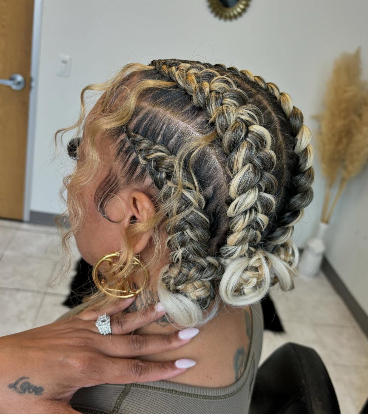 Thick blonde and dark braids loop around the head with curled ends
