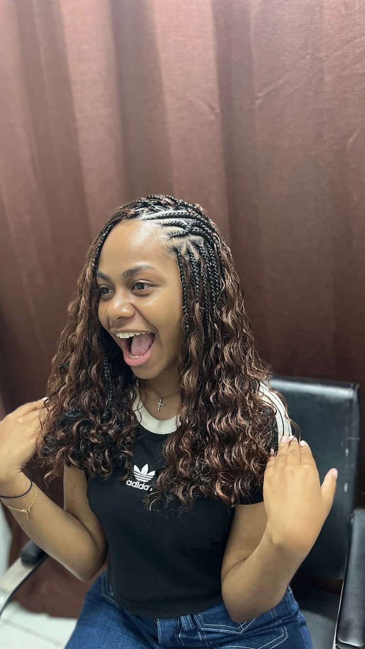 Woman showing Fulani-inspired cornrows with long curly hanging braids