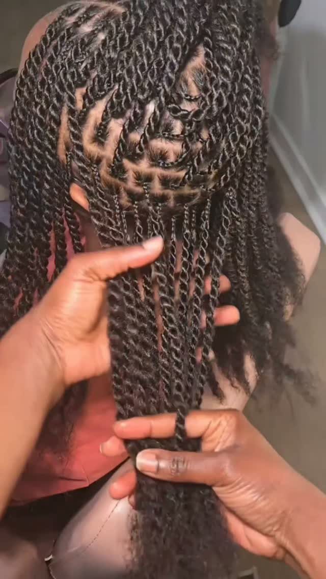 Long dark Senegalese twists are held apart to show neat scalp sections