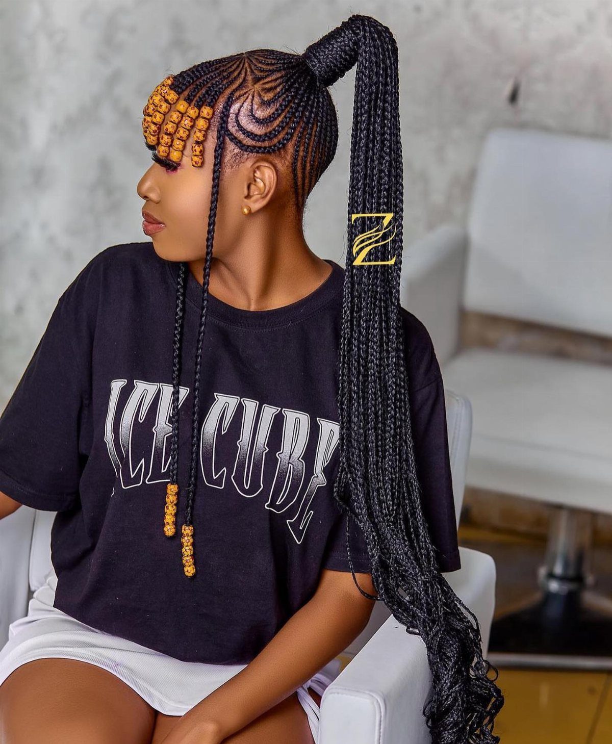 High braided ponytail with orange beads across the forehead and on face-framing braids