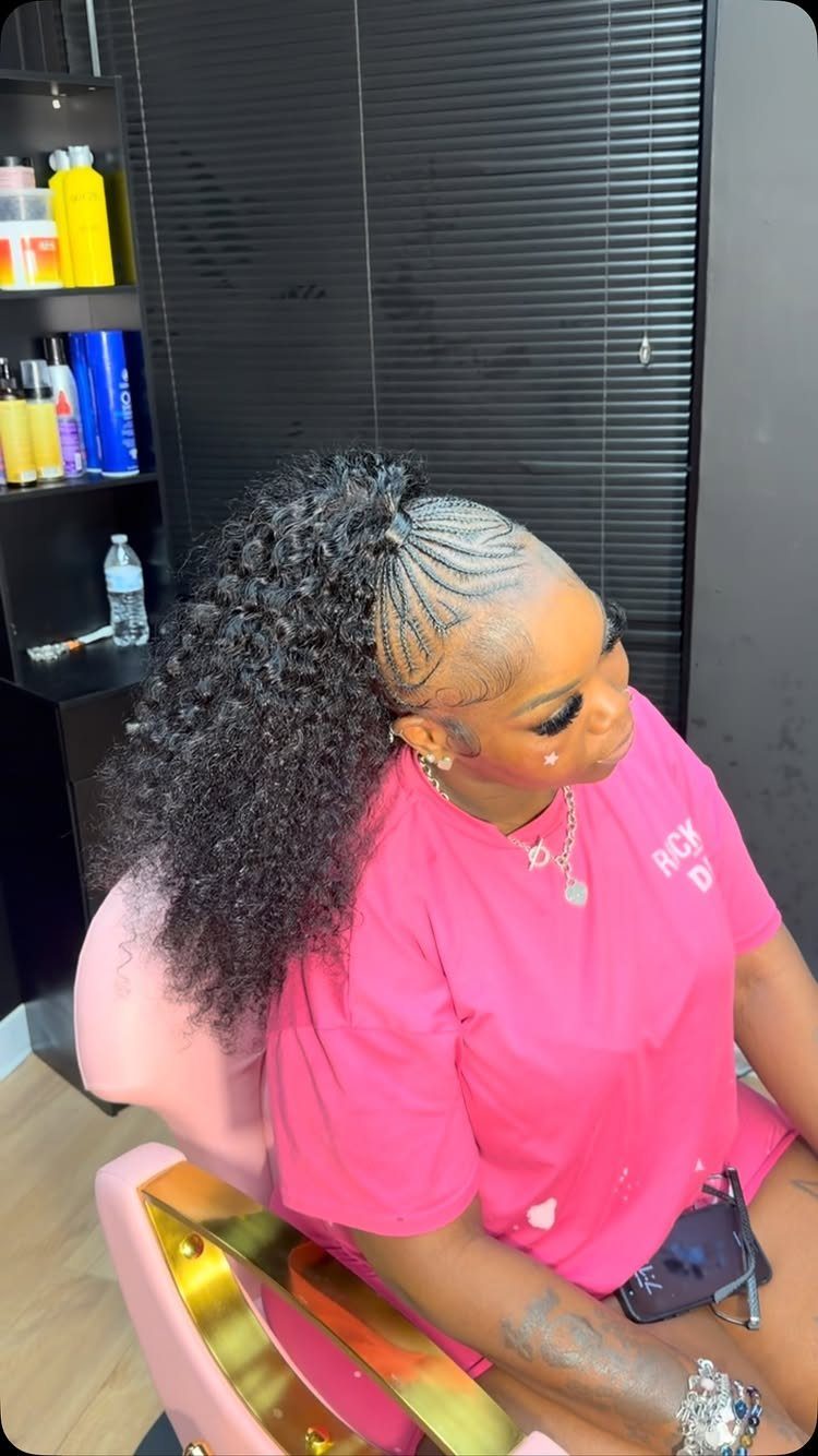 Curved cornrows gathered into a long, voluminous curly ponytail