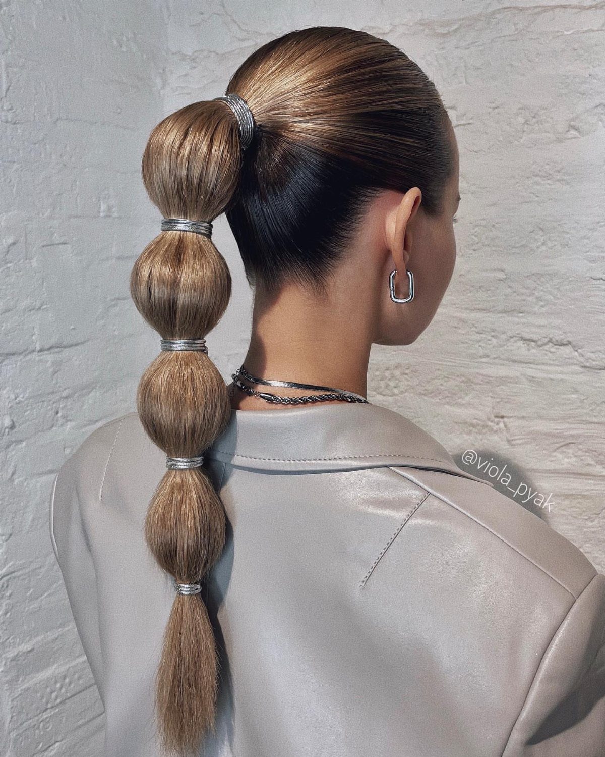 Brown bubble ponytail with rounded sections secured by metallic hair ties