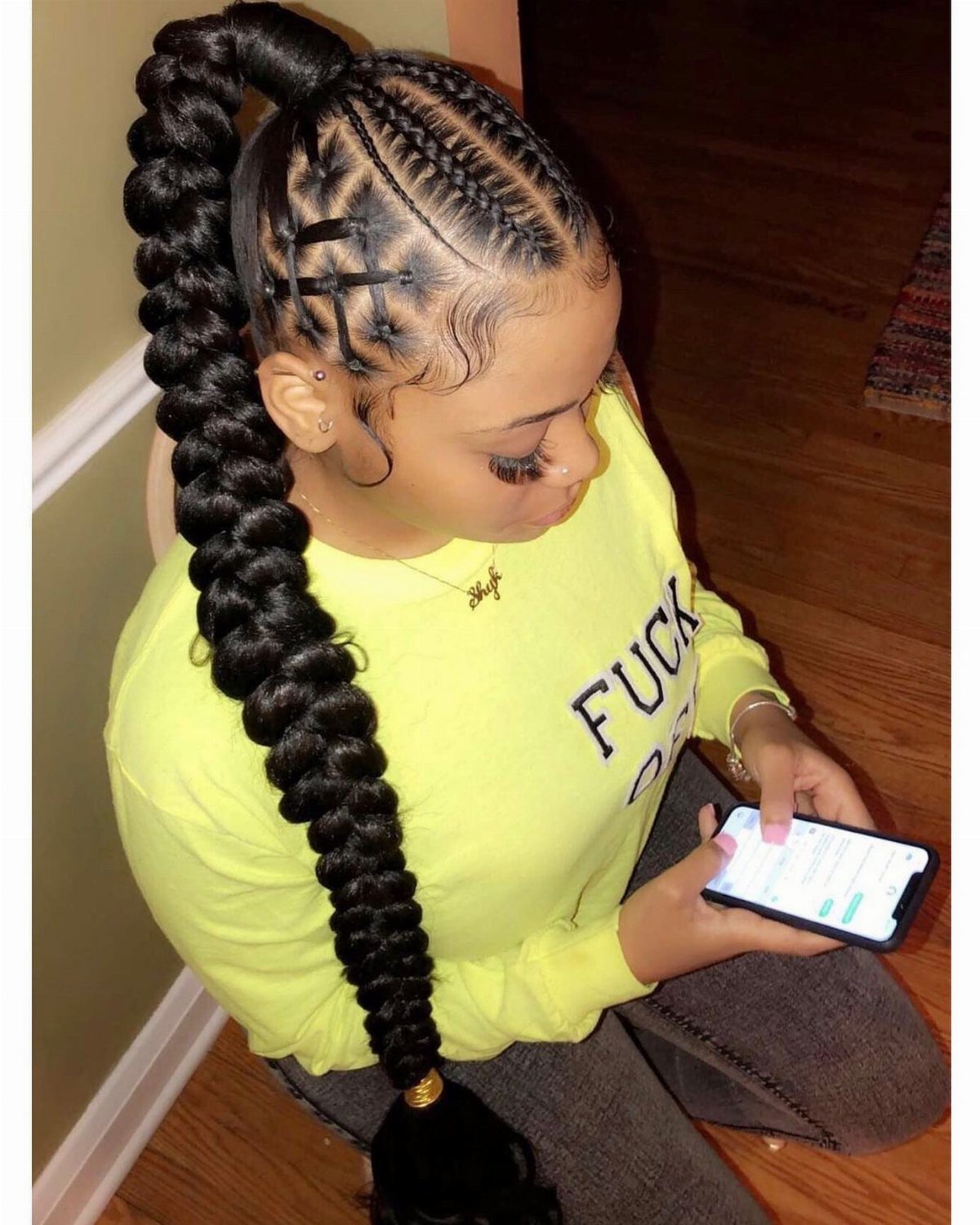 Woman wearing a long, thick braided ponytail with neat scalp braids