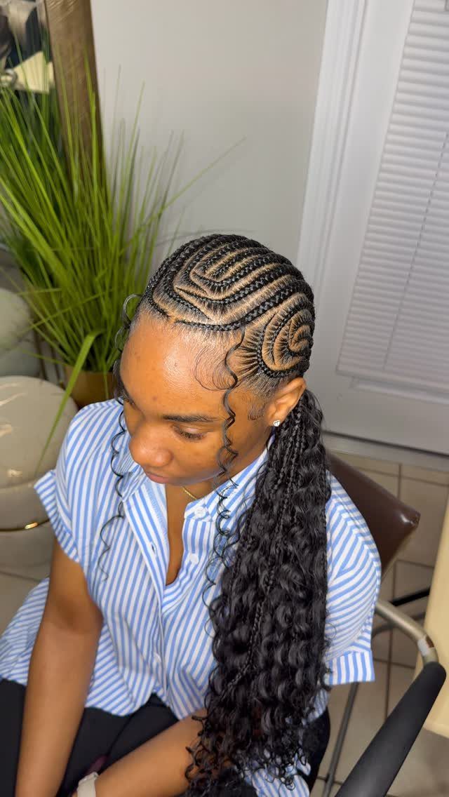 Curved side-swept cornrows gathered into a long braided ponytail
