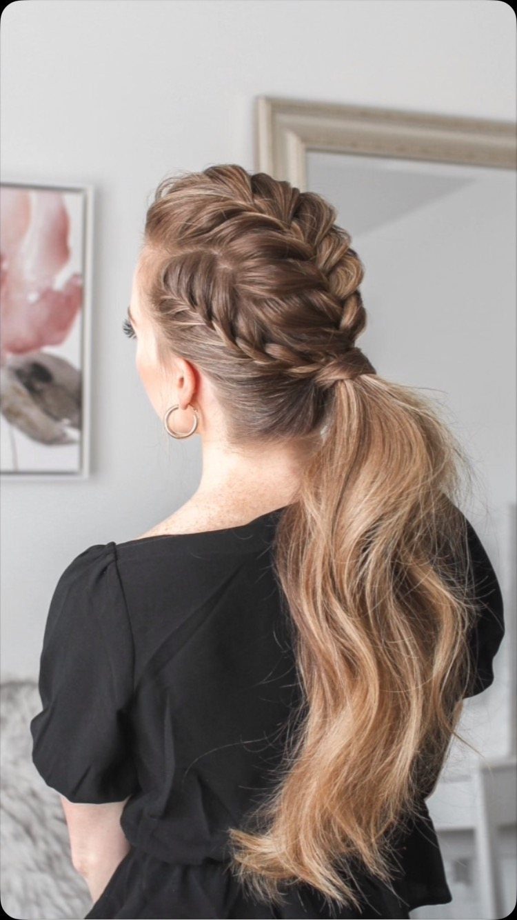 Raised central braid joins a long, loose brown ponytail on a woman