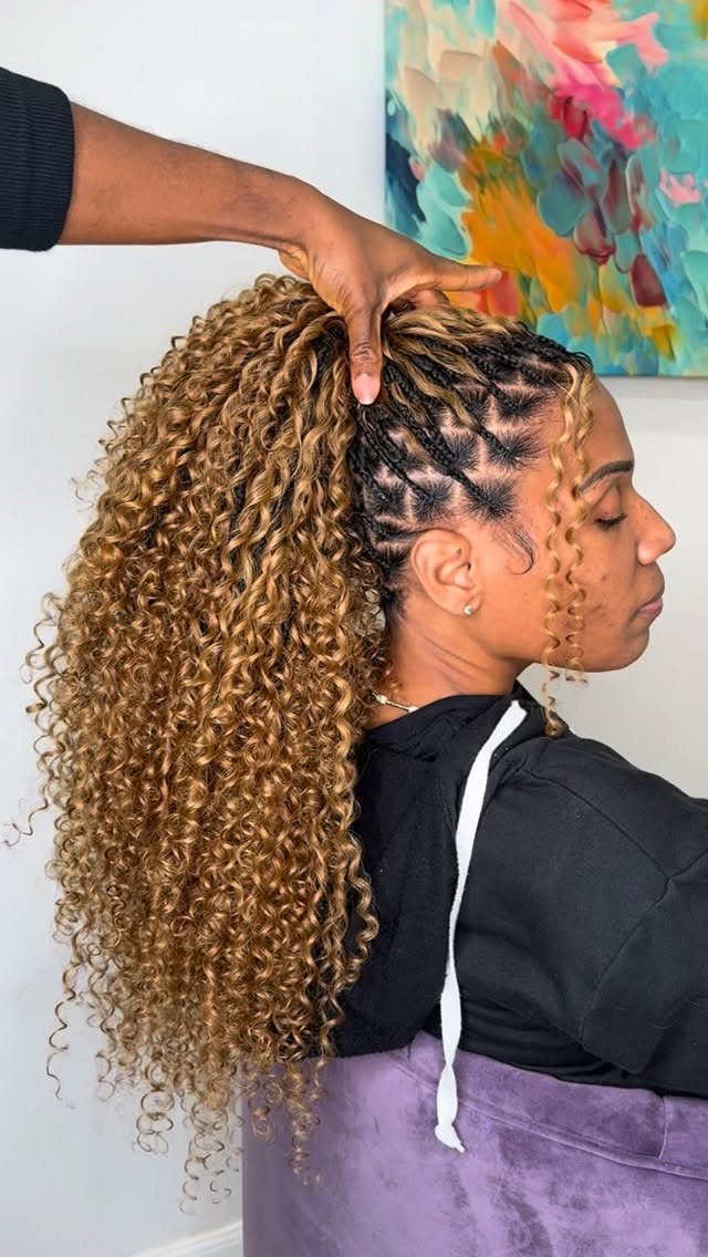Golden-brown curly braided ponytail gathered from dark cornrows