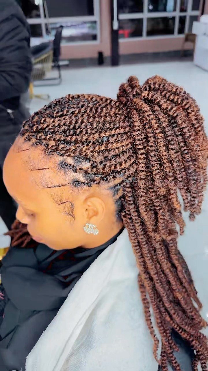 Brown spring twists gathered into a high ponytail on a person in a salon cape