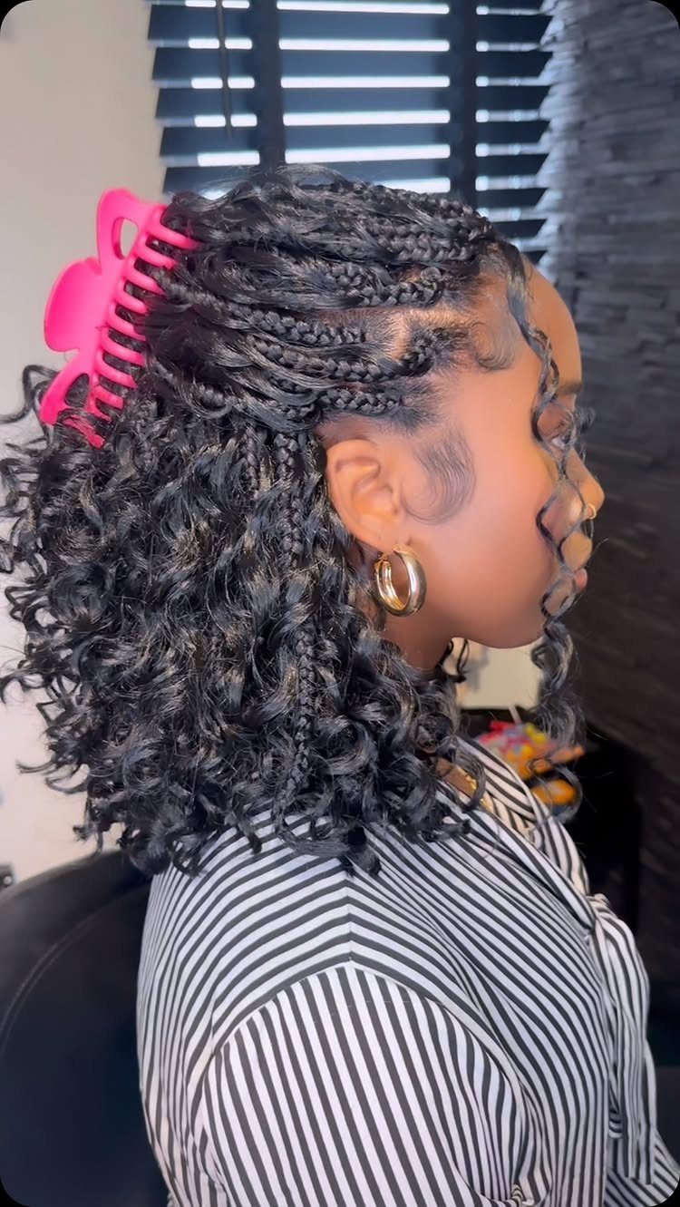 Woman with short braided hair and loose curls held by a pink clip