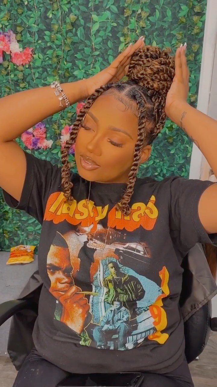 Woman wearing passion twists gathered into a high braided updo