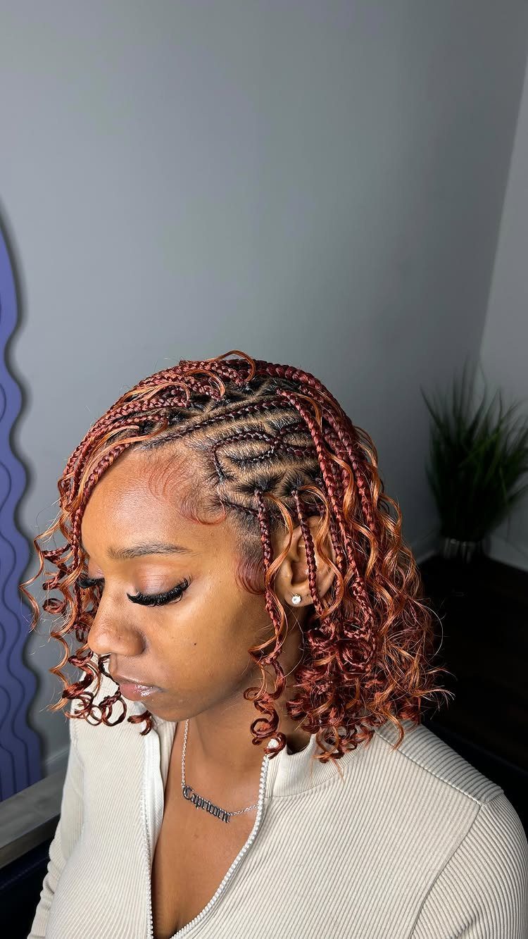 Woman with short reddish-brown braids and curled ends shown in profile