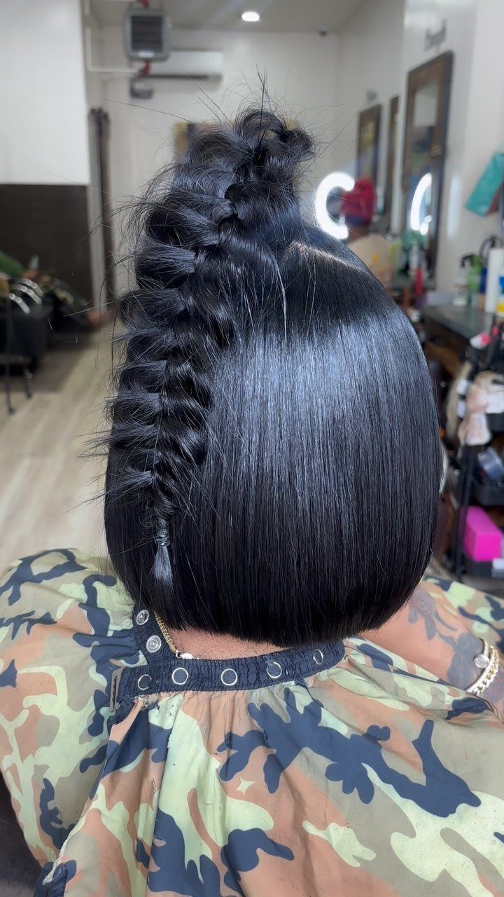 Short black bob with a thick braid down one side in a salon