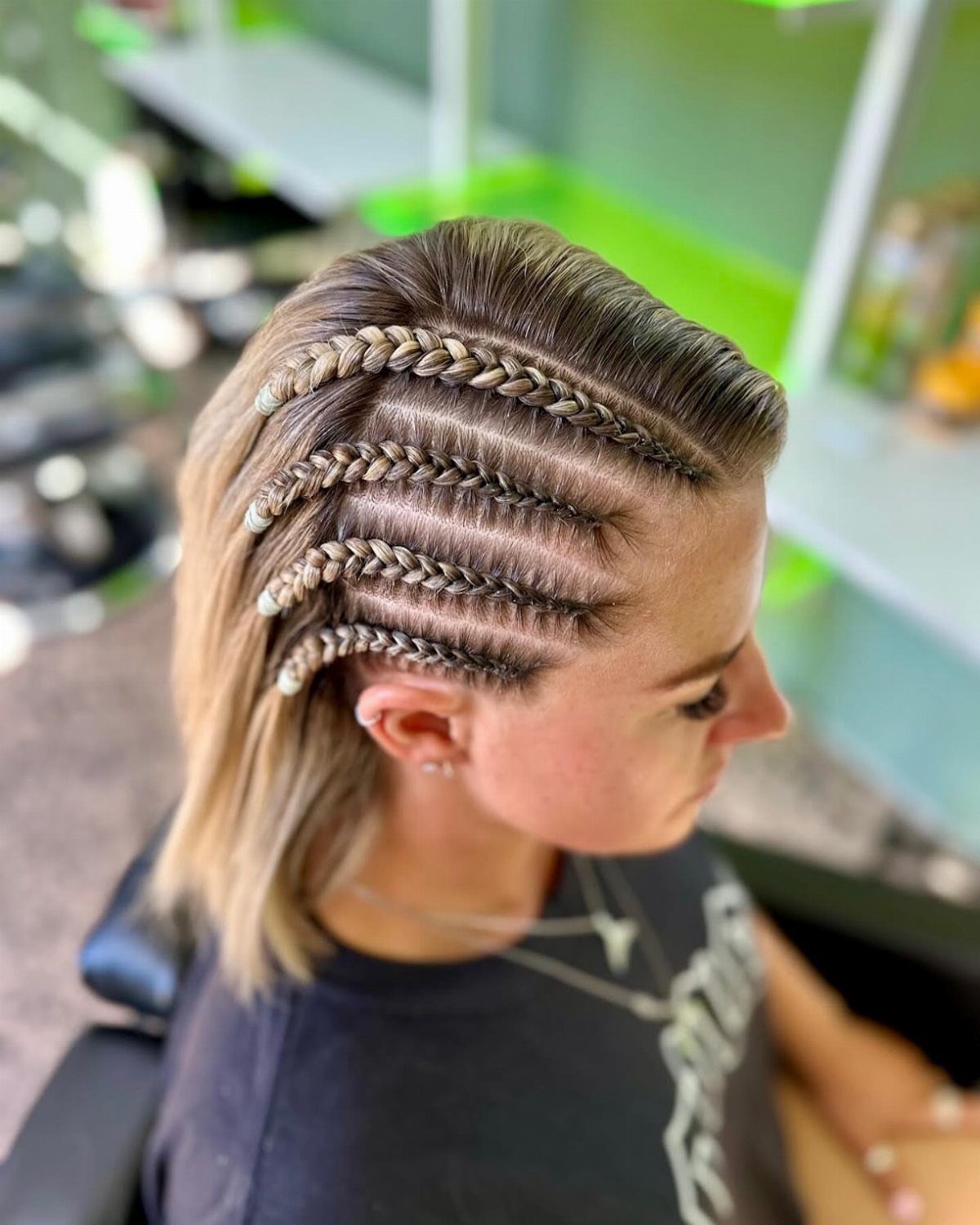 Side cornrows and a raised braid style short light brown hair