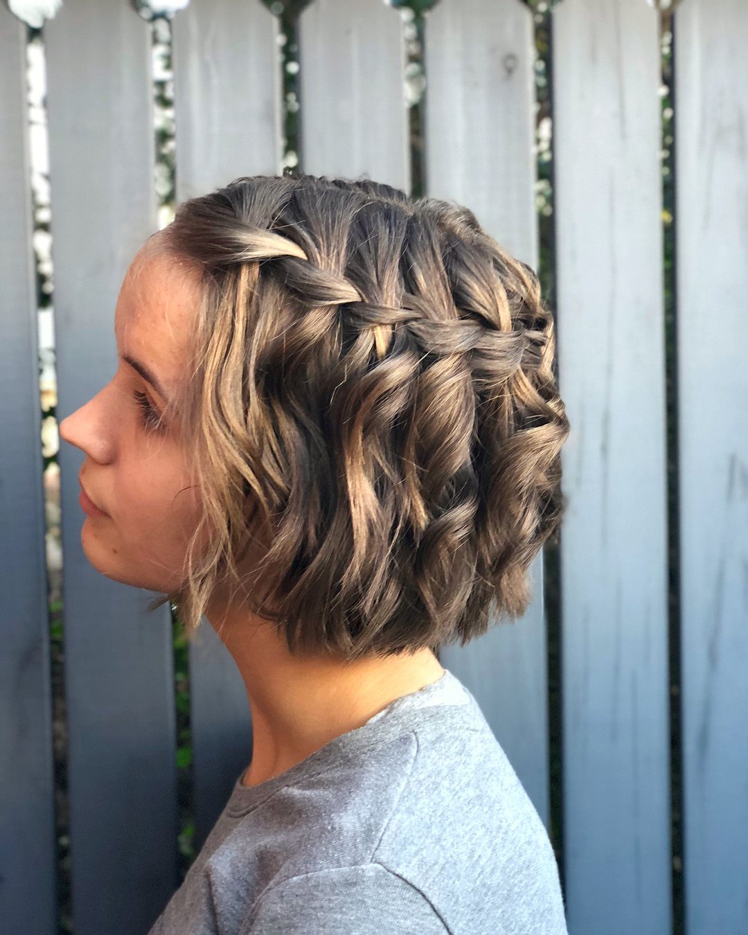 Short wavy brown hair with a crown waterfall braid and loose cascading sections