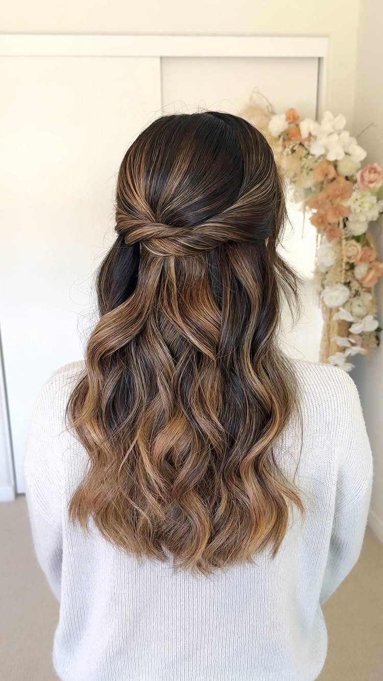 Long wavy brown hair styled in a half-up half-down twist