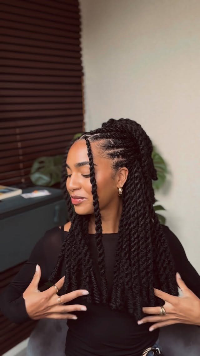 Woman displaying long dark passion twists reaching to mid-back