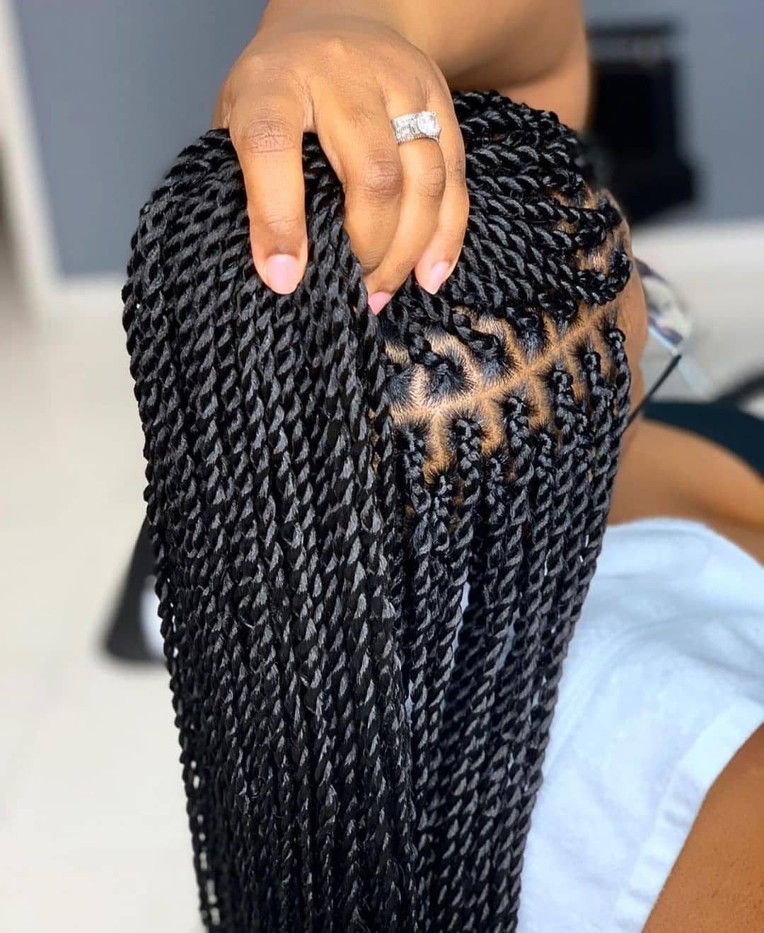 Long black Senegalese twists cascade down a person’s back