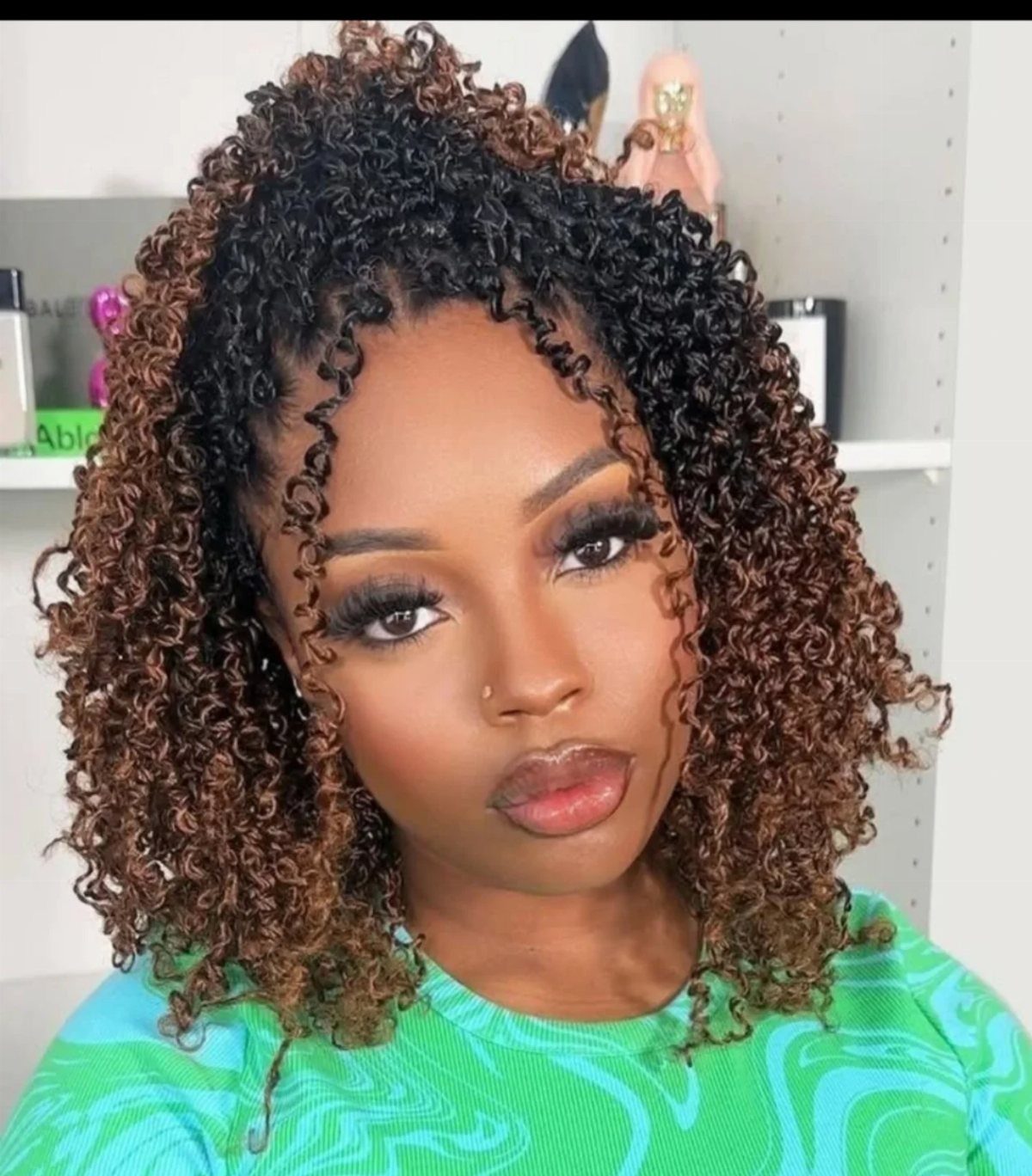 Woman showing fluffy passion twists with dark roots and warm brown highlights