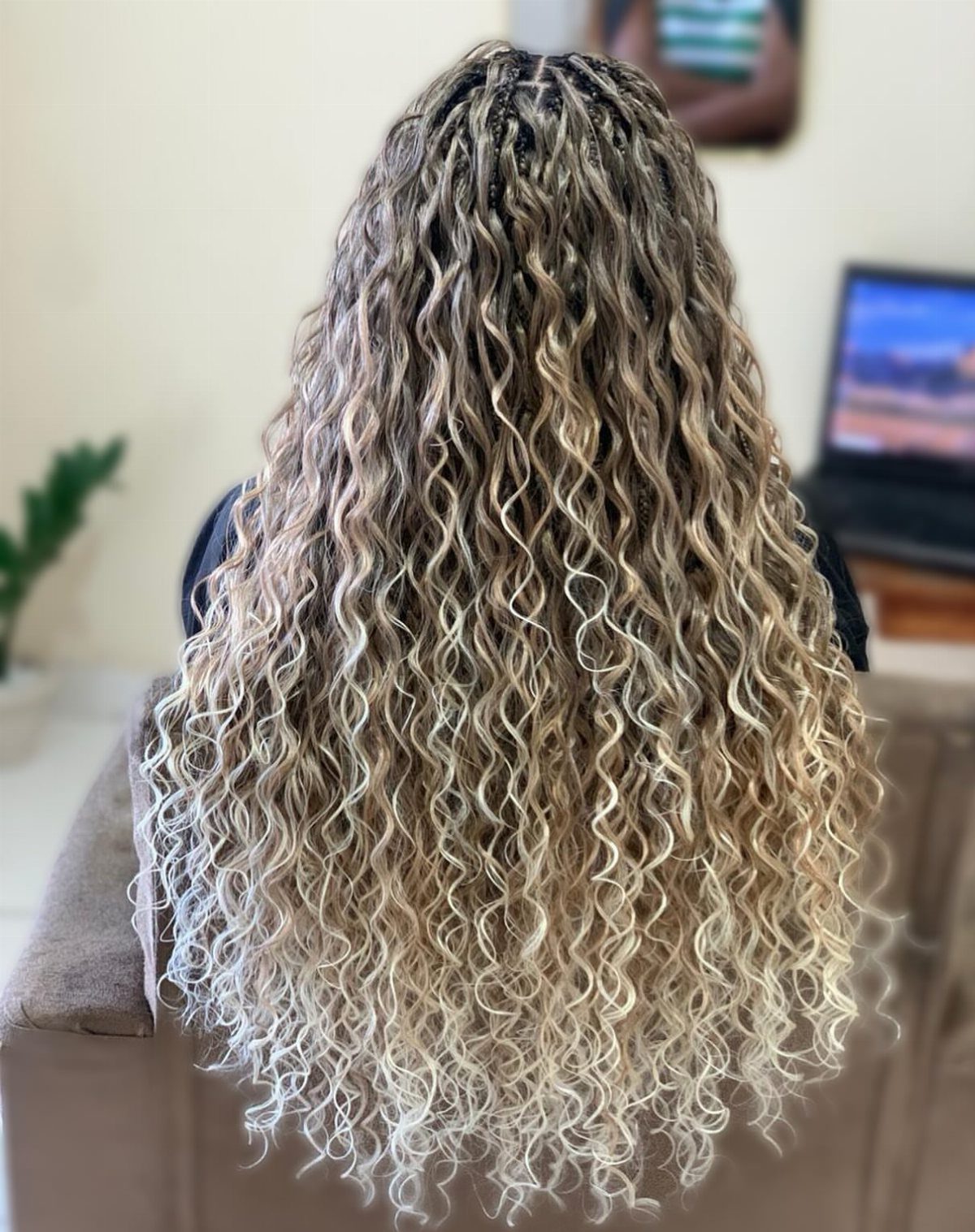 Long white-blonde passion twists cascade down a seated person's back