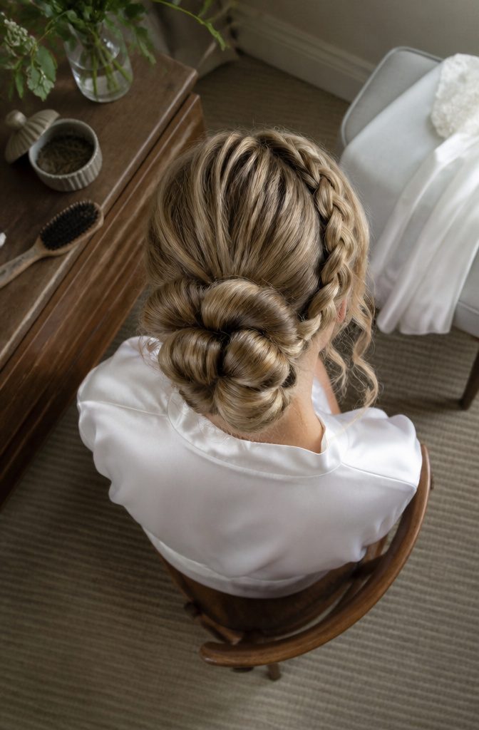Low tucked bun with loose bubble braids framing the face