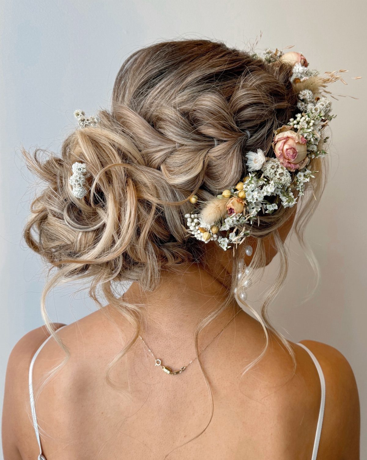 Blonde crown braid woven into a loose floral bun