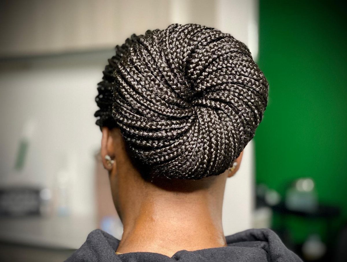 Dark box braids gathered into a large rounded bun at the back of the head