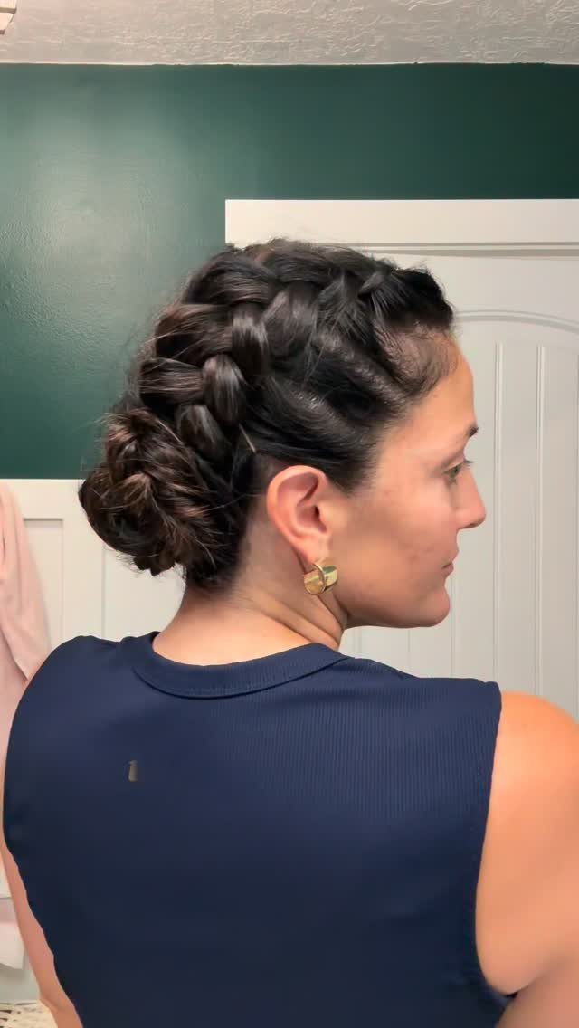 Curved Dutch braid wraps into a low spiraled bun on a woman's head