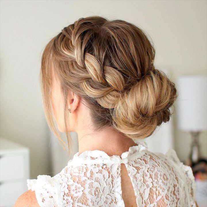 Loose blonde bun with a thick crown braid on a woman wearing white lace