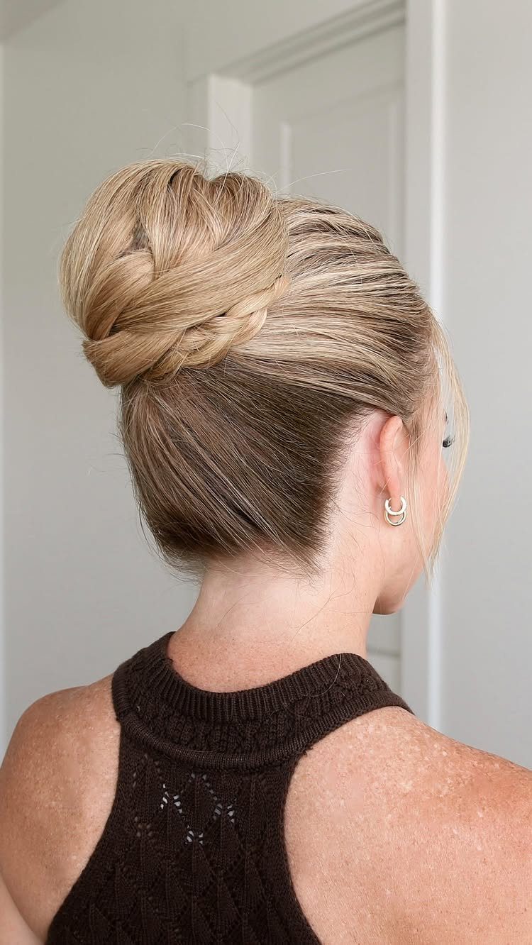 Woman showing a high bun with a thick braided crown detail in blonde hair