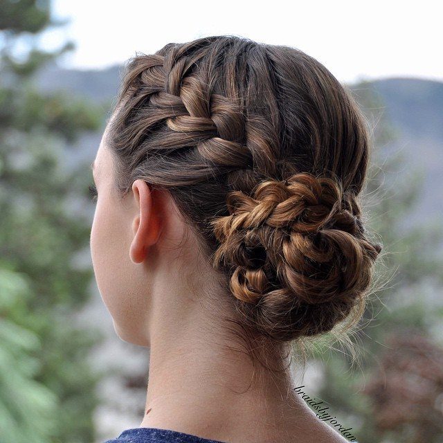 Braided bun gathered at the nape with side braids woven into it