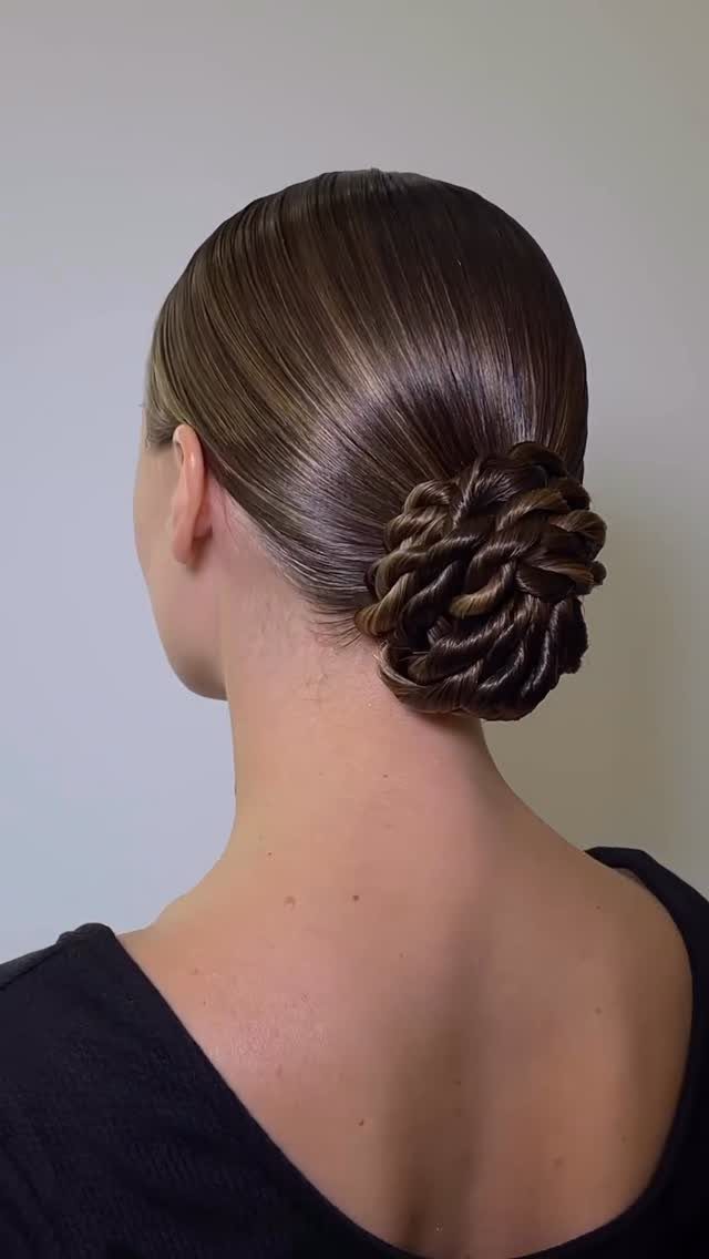 Braided bun arranged at the back of a woman's smooth brown hair